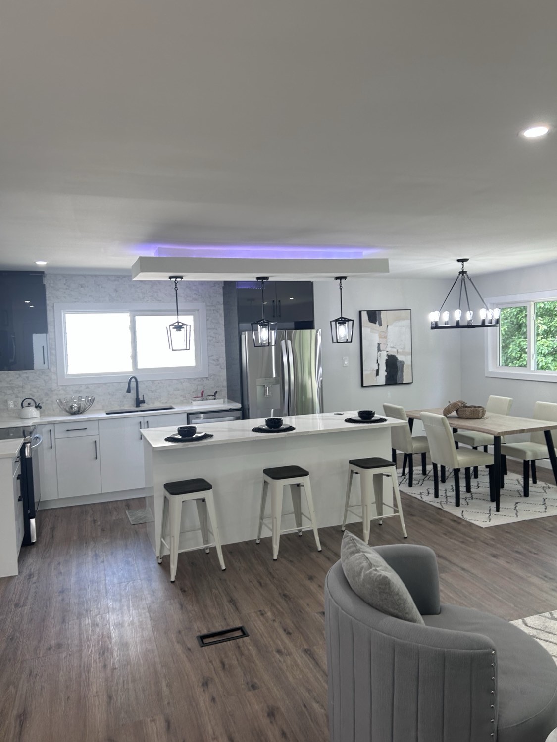 Open-concept kitchen and dining with cove lighting and lantern pendants