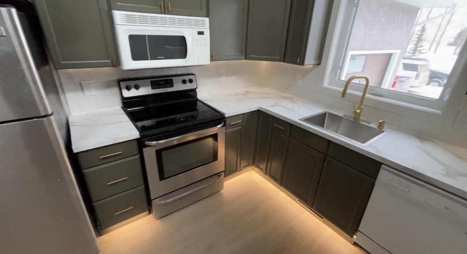 Kitchen with warm toe-kick LED glow and gold fixtures